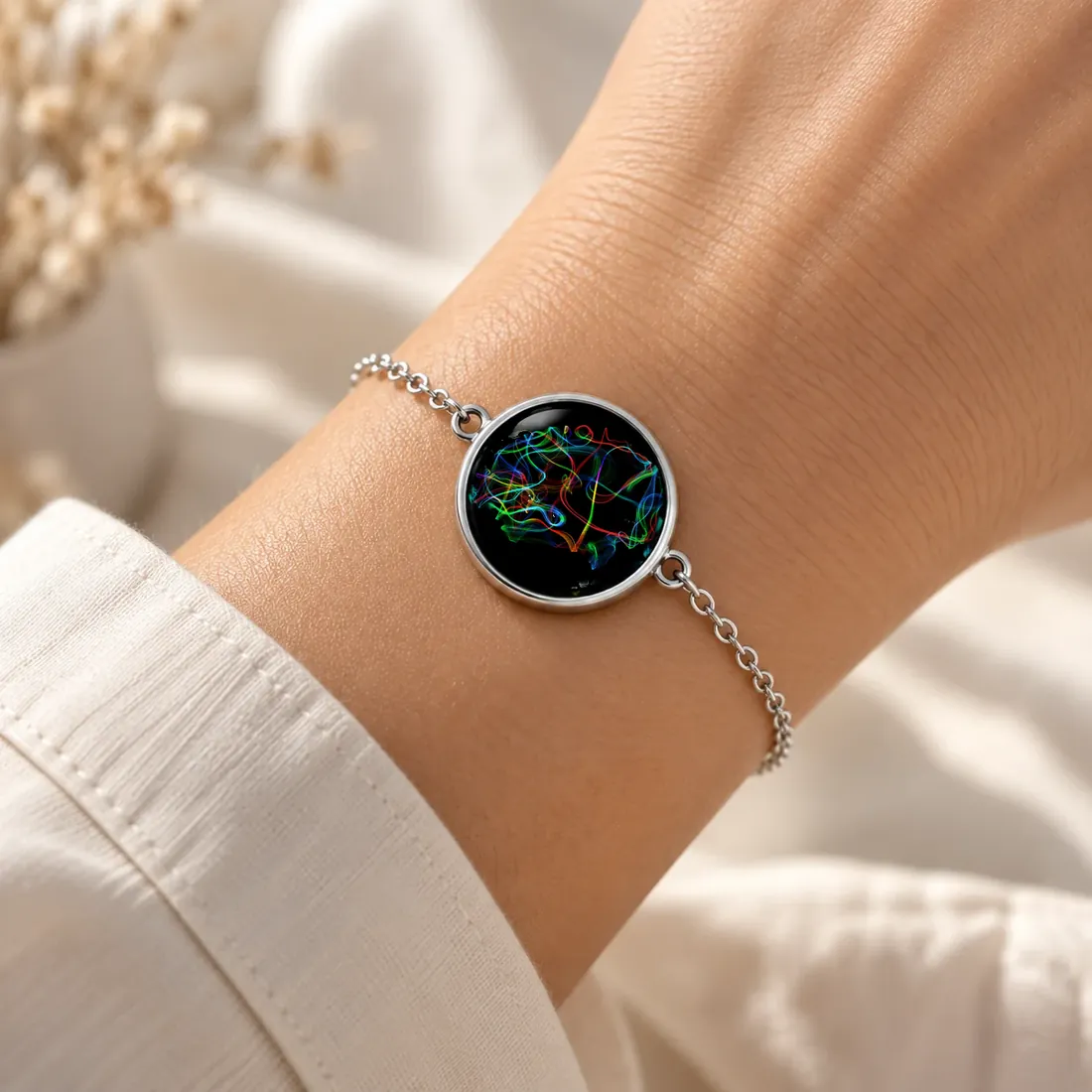 La même œuvre sous verre, sur un bracelet porté au poignet.